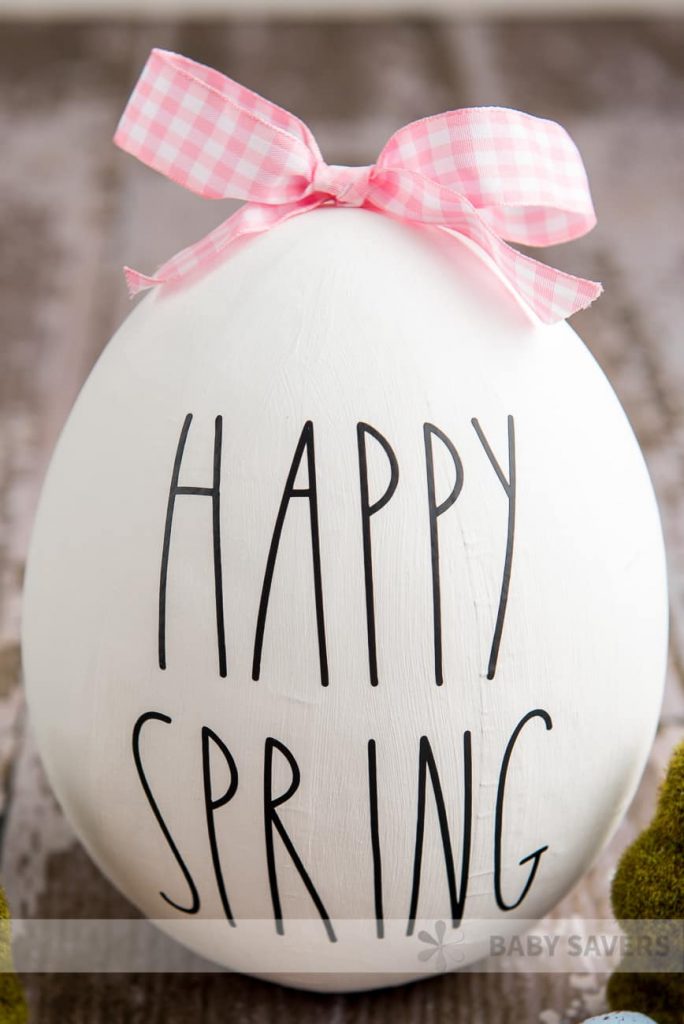 white egg with pink bow and words happy spring